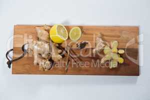 Directly above view of lemon and various spices on wooden serving board