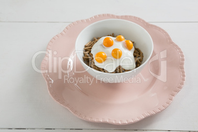 Bowl of cereal bran sticks with yogurt and golden berries