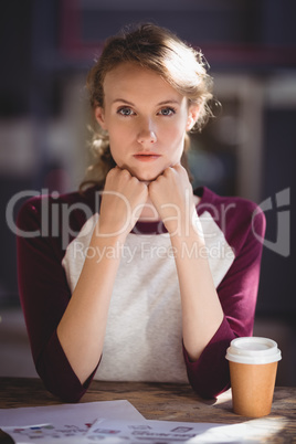 Confident young female design professional sitting at coffee shop