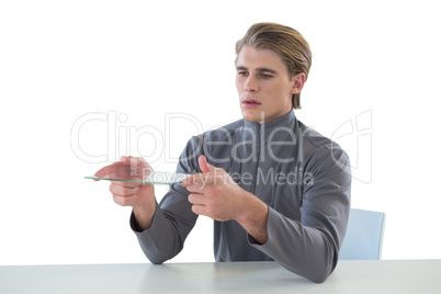 Businessman holding glass interface while sitting at table