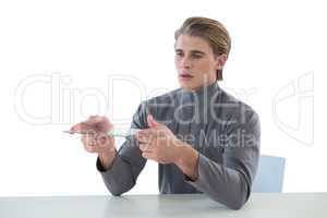 Businessman holding glass interface while sitting at table