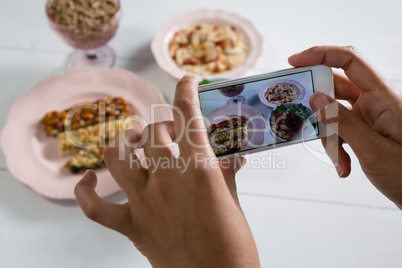 Hands taking photo of breakfast with mobile phone