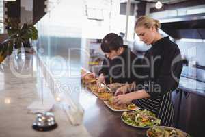 Young female chefs preparing fresh food at cafeteria
