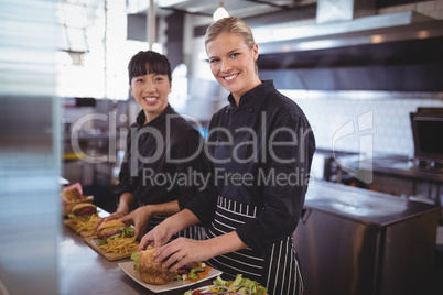 Portrait of smiling female chefs preparing food in kitchen