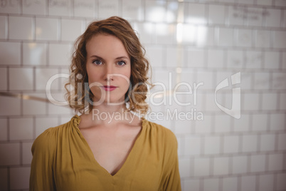 Portrait of confident beautiful woman standing against white wall