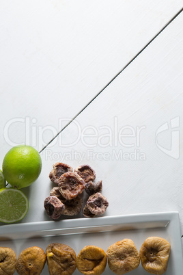 Overhead view of figs by lemons arranged in plate