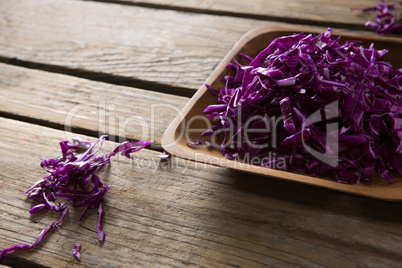 Chopped red cabbage in tray on wooden table