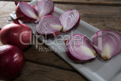 Onions in a tray on a wooden table