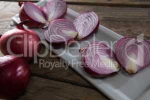 Onions in a tray on a wooden table