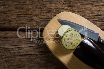 Sliced eggplant with knife on chopping board