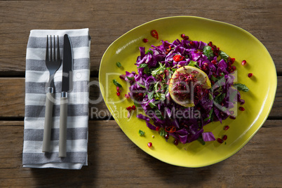 Salad in plate on wooden table