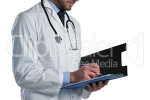 Mid-section of male doctor writing on clipboard