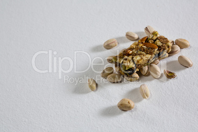 Pistachio and granola bar on white background