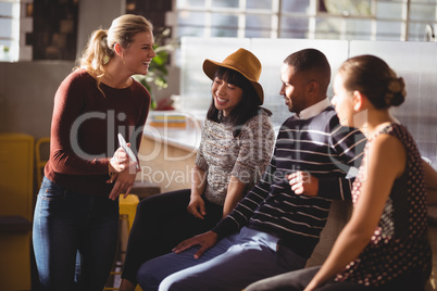 Smiling woman showing mobile phone to friends