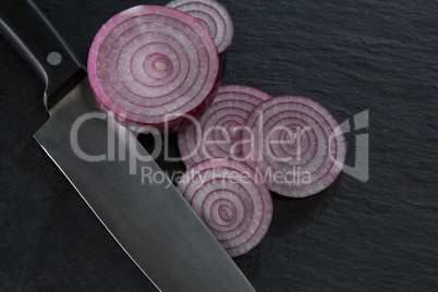 Sliced onions and knife on chopping board