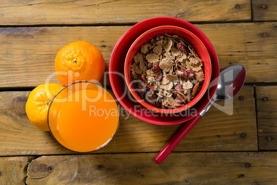 Wheat flakes and orange juice on wooden table