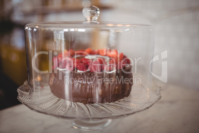 Close up of fresh raspberry cake in glass container on table