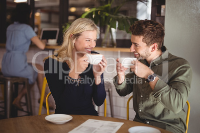 Cheerful couple drinking coffee at cafe