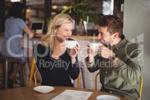 Cheerful couple drinking coffee at cafe