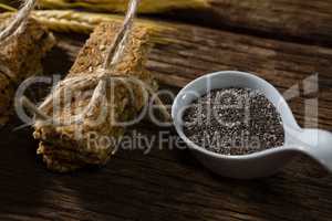 Granola bars tied with string and grains on spoon