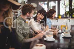 Smiling young friends talking while sitting at table