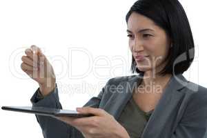 Businesswoman pretending to hold invisible object while using digital tablet
