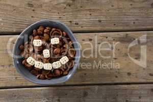Chocolate cornflakes with honeycomb cereal forming smiley face in bowl
