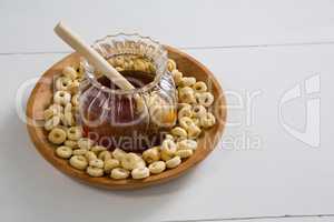 Honey jar with cereal rings in bowl