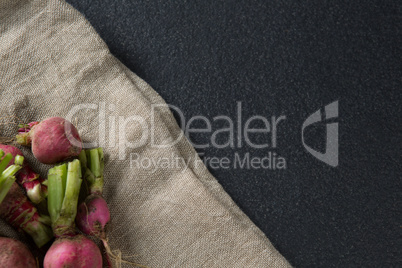 High angle view of red radishes on burlap