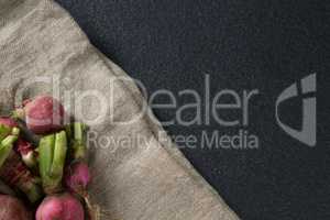 High angle view of red radishes on burlap