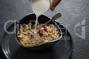 Milk being poured into wheat flakes bowl