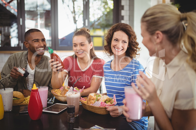 Young friends talking while sitting at cafe