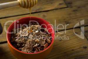 Honey pouring into a cereal bowl