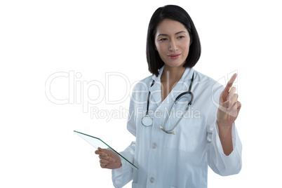 Female doctor holding a glass digital tablet while touching invisible screen Female doctor holding a glass digital tablet while touching invisible screen