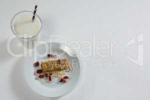 Granola bar and milk on white background