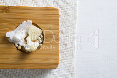 Overhead view of cauliflower with cheese and peppercorn on cutting board
