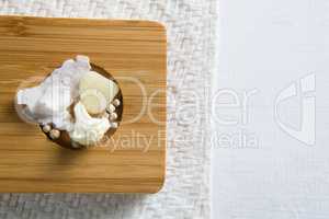 Overhead view of cauliflower with cheese and peppercorn on cutting board