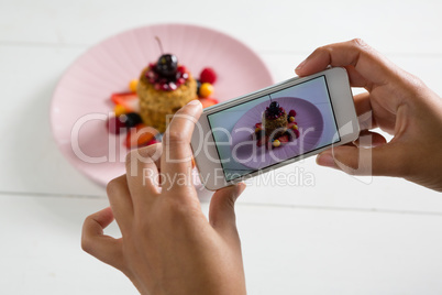 Hands taking photo of breakfast with mobile phone