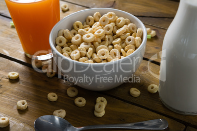 Cereal rings, orange juice and milk on wooden table