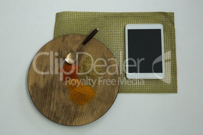 Various type of spices on wooden board with digital tablet