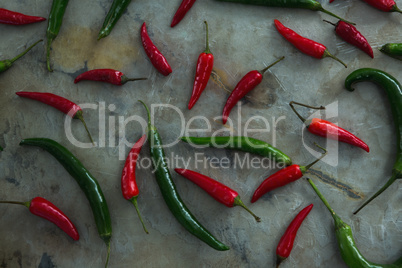 Green and red chili pepper on table