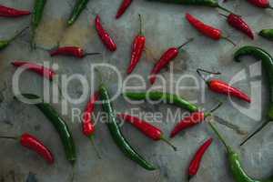 Green and red chili pepper on table