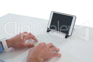 Cropped hands of businessman typing on imaginary keyboard while using digital tablet