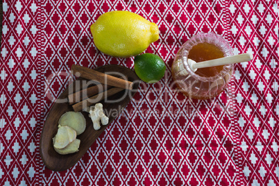 Citrus fruit , cinnamon sticks and honey on a place mat