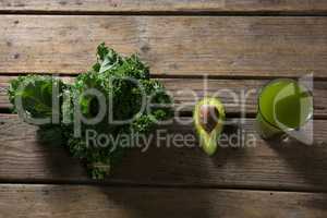 Mustard greens, avocado and juice on wooden table