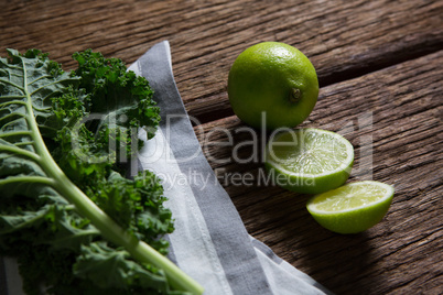Mustard greens and lemon on wooden table