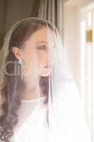 Close up of beautiful bride standing by window