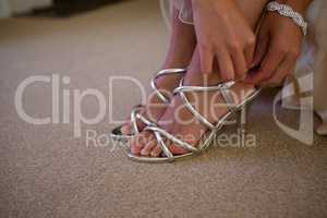 Bride wearing silver sandals in house