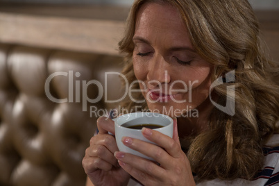 Happy woman smelling coffee