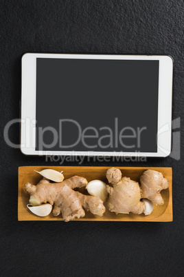 Ginger and garlic in tray with digital tablet